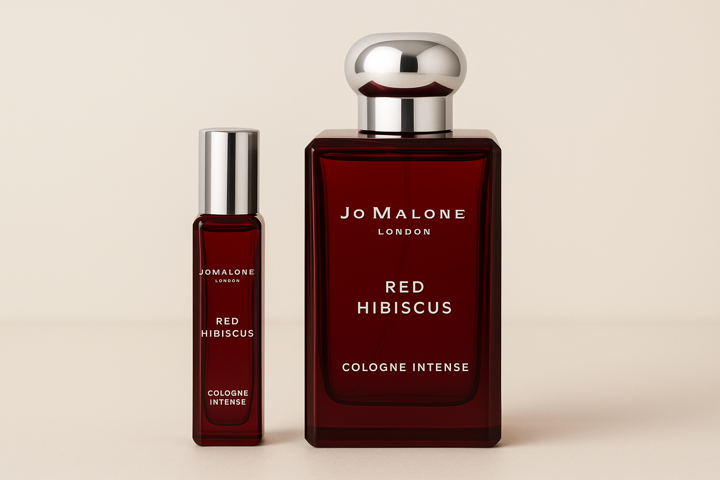 ジョー マローン レッド ハイビスカス コロン インテンス 12ml サンプルが、濃い赤色のボトルに白い文字が書かれたジョー マローン レッド ハイビスカス コロン インテンスの 100ml 香水ボトルの横に立っています。